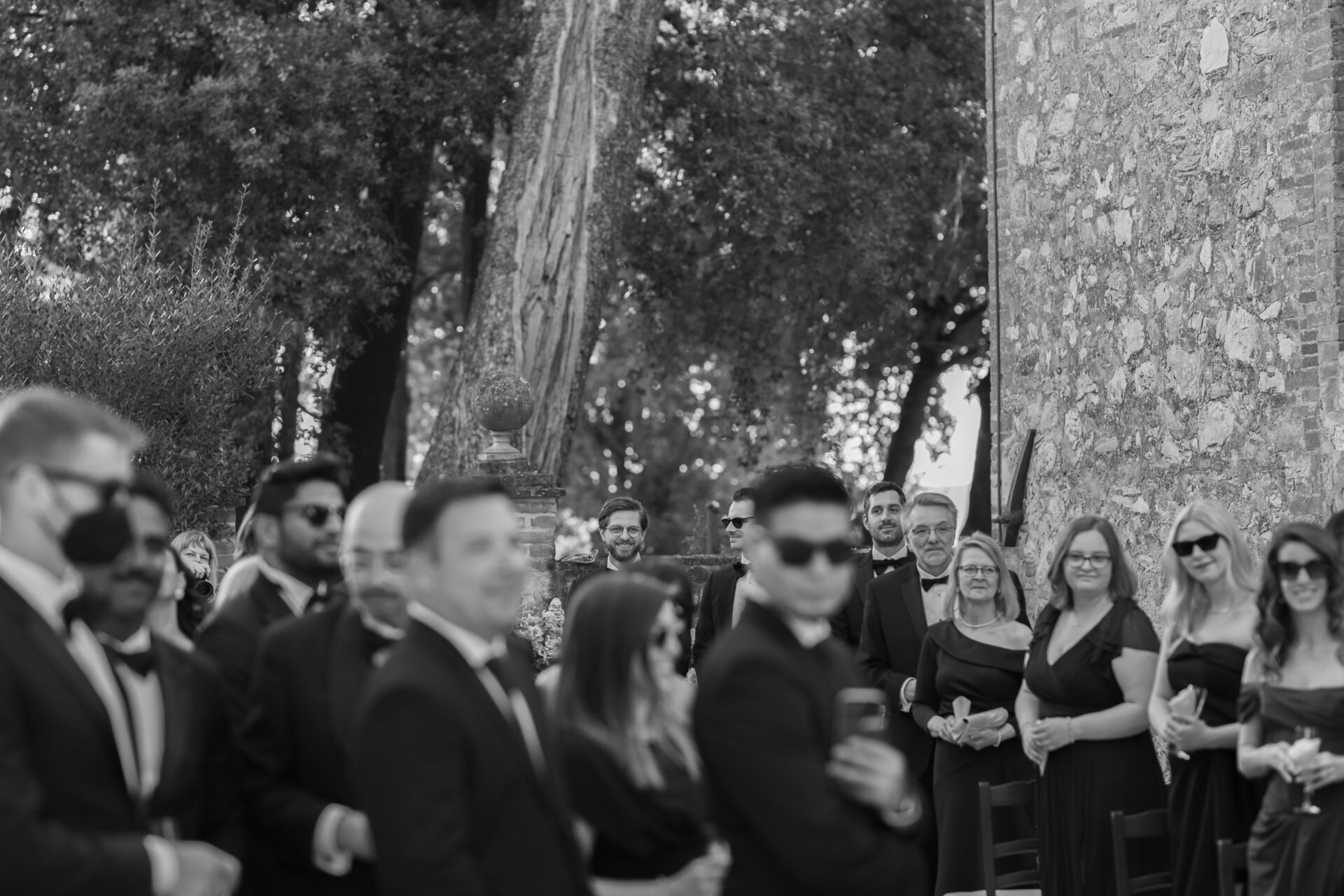 The groom watches his bride approach down the aisle at his Italian wedding