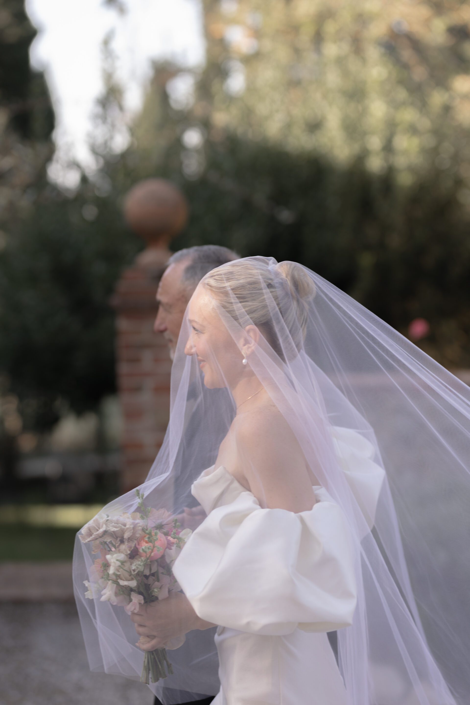 The bride makes her way down the aisle at her Tuscan wedding, captured with Italian wedding photography