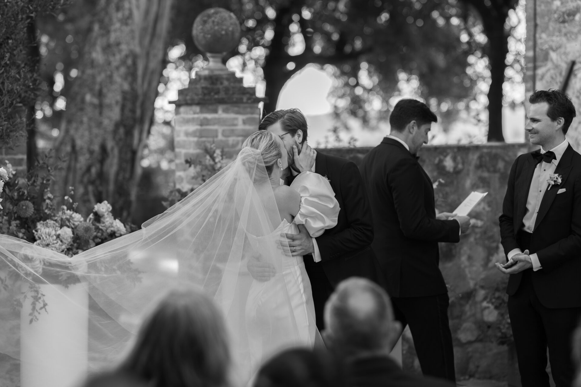 The bride and groom share their first kiss during their luxury Tuscan wedding ceremony