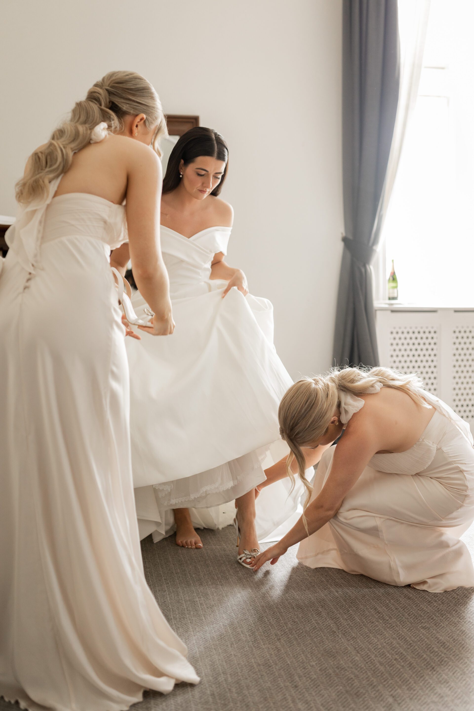 The bridal party help the bride get ready for her wedding at Tortworth Court
