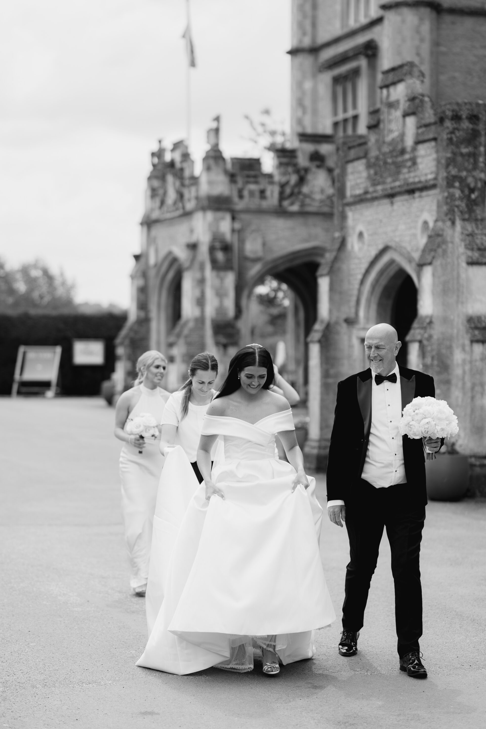 The bride walks to her wedding ceremony with her father and bridesmaids at Tortworth Court